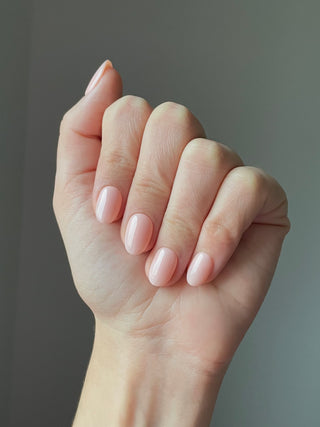 Les press on nails sans colle sur cette main est le modèle court rond nude beige. ils sont faits à la mains en France.