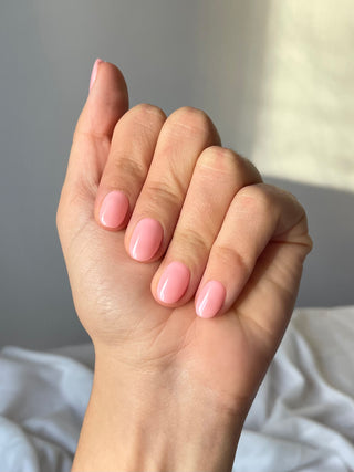 Une manucure réutilisable avec des capsule vernis de gel rose, effet nude. Forme courte et ronde.