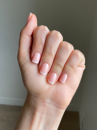 Les ongles présentés sont des press   on de style french manucure de couleur beige et de forme carrée.