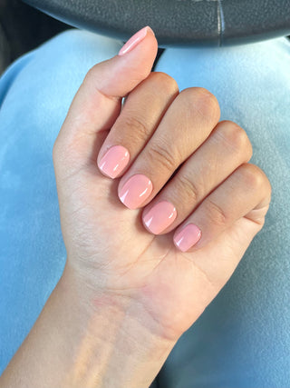 Manucure faux ongles du modèle court de forme carrée et de couleur nude saumon rose.