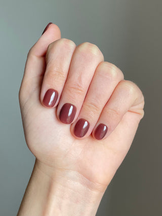 Press on nails sans colle, couleur nude marron unie et de longueur extra-courtportée sur tous les doigts.